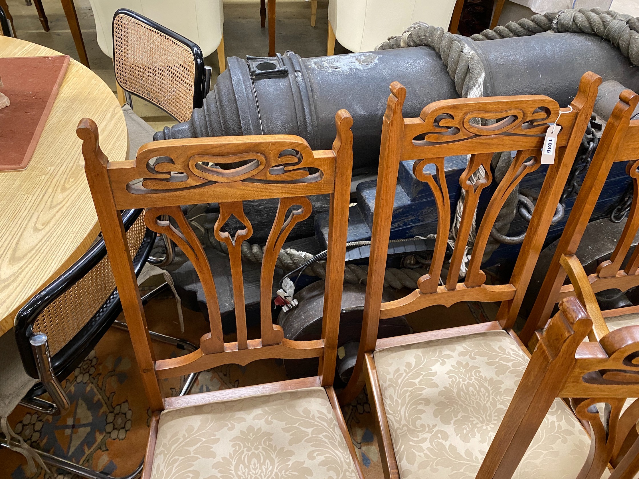 Five Art Nouveau walnut dining chairs, one with arms